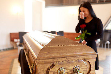 Image showing woman with coffin crying at funeral in church