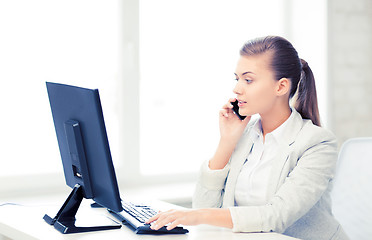 Image showing businesswoman with smartphone in office