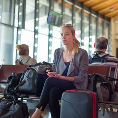 Image showing Female traveler using cell phone while waiting on airport.