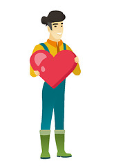 Image showing Asian farmer holding a big red heart.