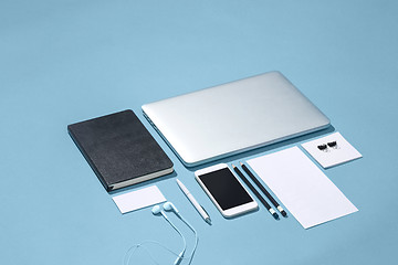 Image showing The laptop, pens, phone, note with blank screen on table