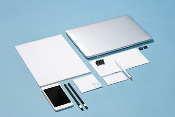 Image showing The laptop, pens, phone, note with blank screen on table