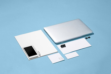 Image showing The laptop, pens, phone, note with blank screen on table