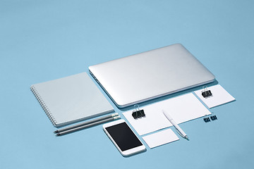 Image showing The laptop, pens, phone, note with blank screen on table