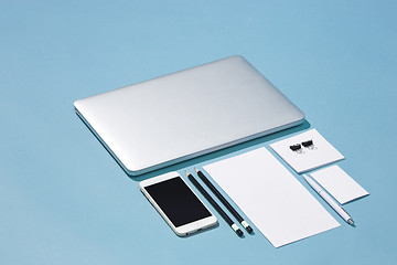 Image showing The laptop, pens, phone, note with blank screen on table