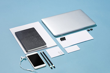 Image showing The laptop, pens, phone, note with blank screen on table