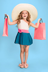 Image showing The cute little caucasian brunette girl in dress holding shopping bags