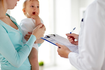 Image showing woman, baby and doctor with clipboard at clinic