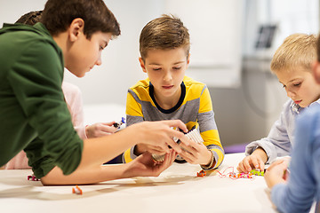 Image showing happy children building robots at robotics school