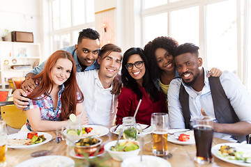 Image showing happy friends eating at restaurant