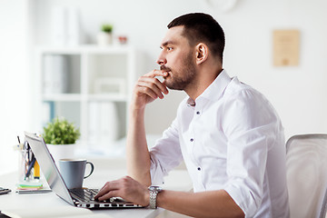 Image showing businessman with laptop thinking at office