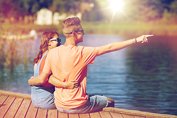 Image showing happy couple pointing finger on summer river berth