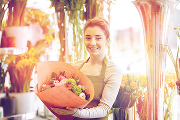 Image showing smiling florist woman with bunch at flower shop