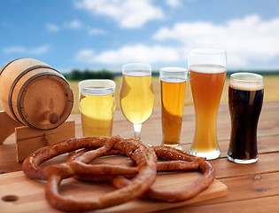 Image showing beer glasses, barrel and pretzel over cereal field