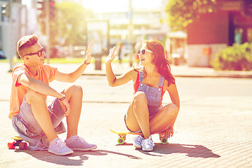 Image showing teenage couple with skateboards on city street