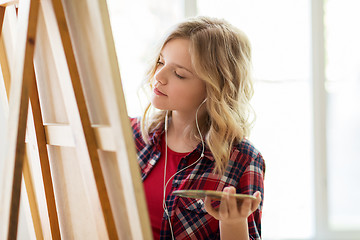 Image showing student girl with easel painting at art school