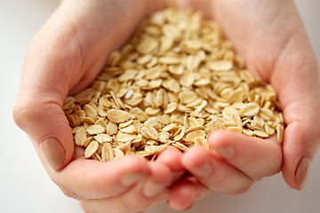 Image showing close up of hands holding oat flakes