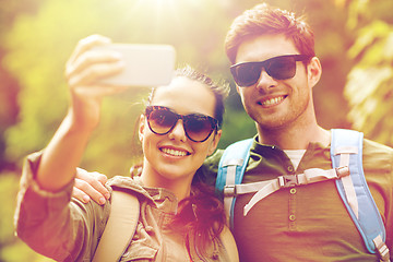 Image showing couple with backpacks taking selfie by smartphone