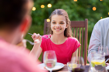 Image showing happy girl eating with family at summer garden