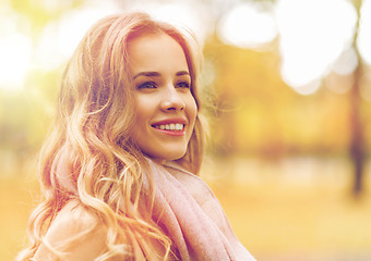 Image showing beautiful happy young woman smiling in autumn park