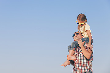 Image showing Dad and daughter in sunglasses playing in the park at the day ti