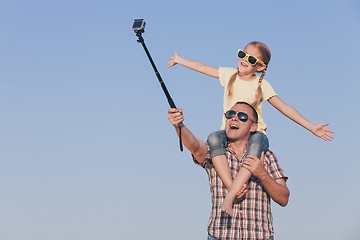 Image showing Dad and daughter in sunglasses playing in the park at the day ti