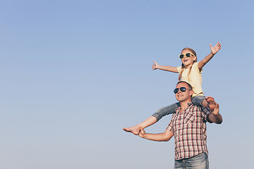 Image showing Dad and daughter in sunglasses playing in the park at the day ti