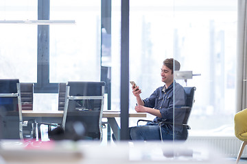 Image showing Young casual businessman using smartphone