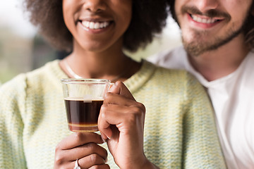 Image showing happy multiethnic couple relaxing at modern home indoors