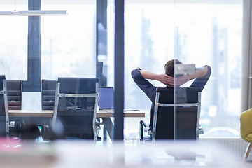 Image showing young businessman relaxing at the desk