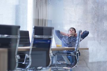 Image showing young businessman relaxing at the desk