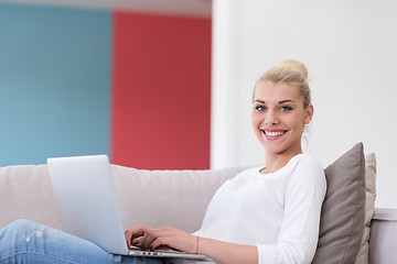 Image showing Young woman using laptop at home