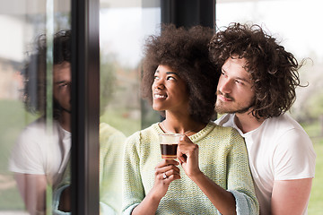 Image showing happy multiethnic couple relaxing at modern home indoors