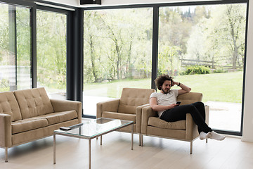 Image showing young man using a mobile phone  at home