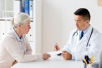 Image showing woman and doctor with prescription at clinic