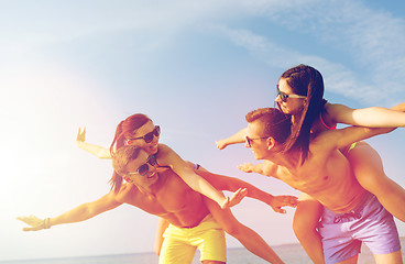 Image showing smiling friends having fun on summer beach