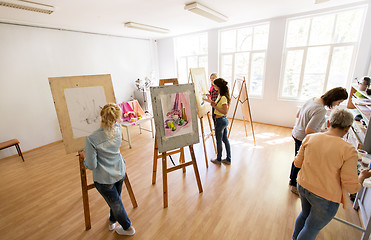 Image showing woman artists with brushes painting at art school