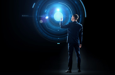 Image showing businessman in suit touching virtual projection