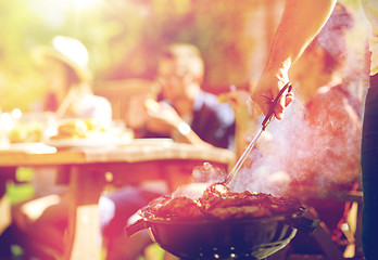 Image showing man cooking meat on barbecue grill at summer party