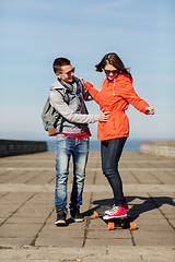 Image showing happy couple with longboard riding outdoors