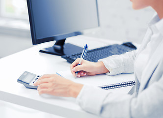 Image showing businesswoman with notebook and calculator