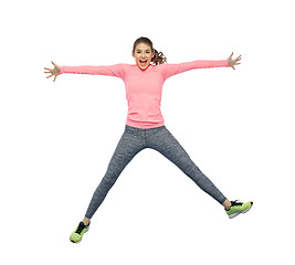 Image showing happy smiling sporty young woman jumping in air