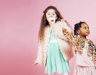 Image showing lifestyle people concept: diverse nation children playing together, caucasian boy with african little girl holding candy happy smiling