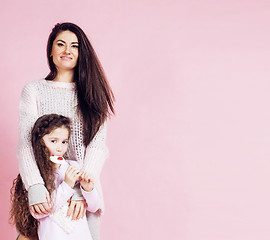 Image showing young mother with little cute daughter emotional posing on pink background, happy smiling family inside isolated adorable, lifestyle people concept 