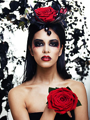 Image showing pretty brunette woman with rose jewelry, black and red, bright m