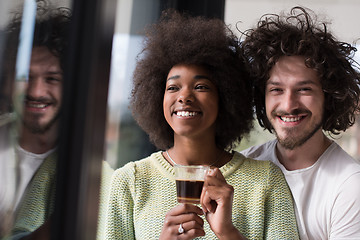 Image showing happy multiethnic couple relaxing at modern home indoors