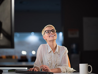 Image showing woman working on computer in dark office