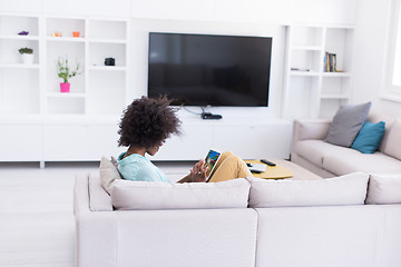 Image showing african american woman at home using digital tablet