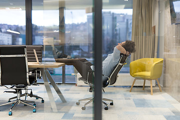 Image showing young businessman relaxing at the desk