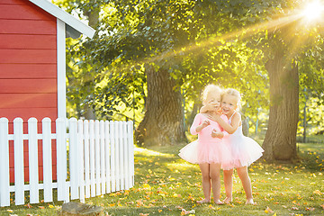 Image showing The two little girls at playground against park or green forest